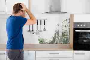 Young Man Shocked On Seeing Mold On Wall In Kitchen