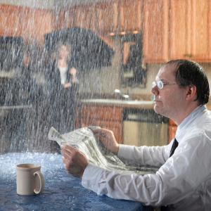 Man reading newspaper at dining table with pipe spewing water in background after hail