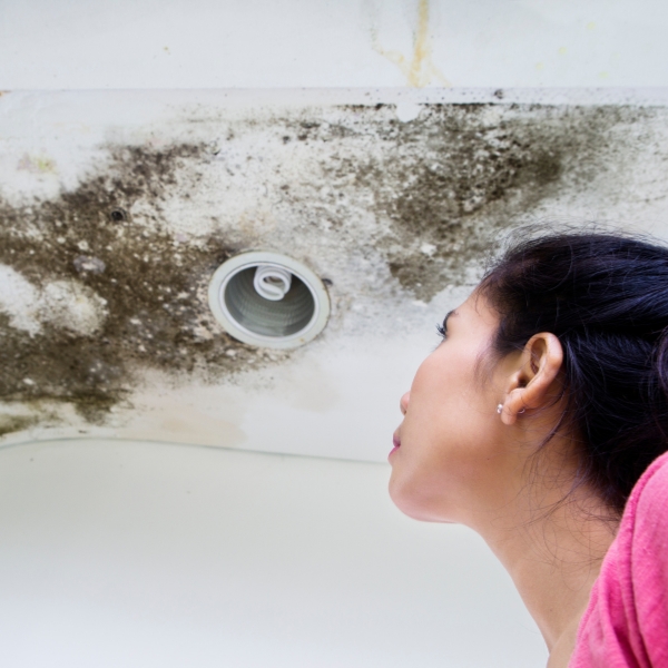 Woman looking at mold growth on ceiling