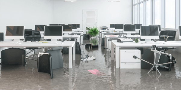 commercial building flooded with desks and office chairs overturned