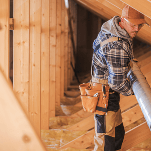 man installing ventilation in attic to prevent mold