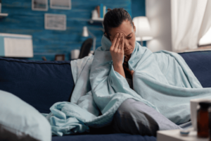 woman on sofa suffering from migraine from Long-Term Exposure to Mold